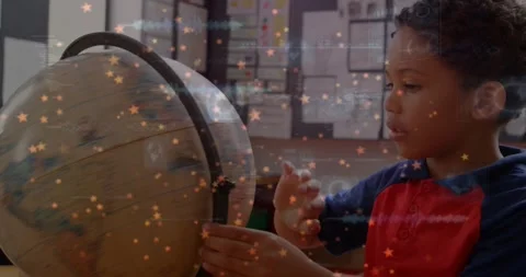 Boy leaning and touching globe, rotating and pointing at map while learning at Vidéo 330981210