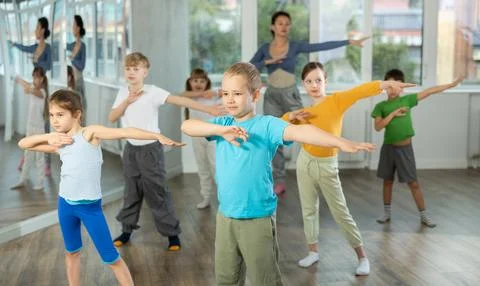 Boy learn to dance modern dances, repeat movement with unrecognizable teacher. Stock Photos