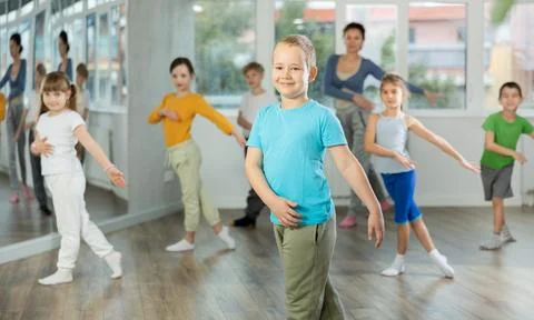 Boy learn to dance modern dances, repeat movement with unrecognizable teacher. Foto stock