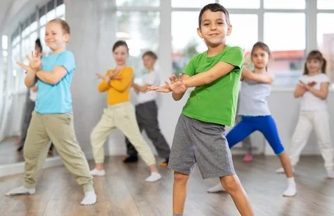 Boy learn to dance modern dances, repeat movement with unrecognizable teacher. Stock Photos