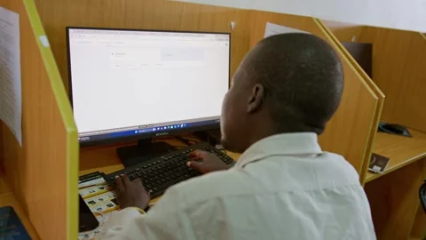 Boy learning computer skills at NGO training center with desktop workstation in 動画素材 347138517