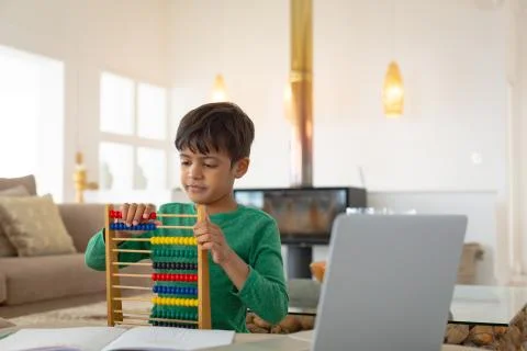 Boy learning mathematics with abacus in a comfortable home 스톡 사진