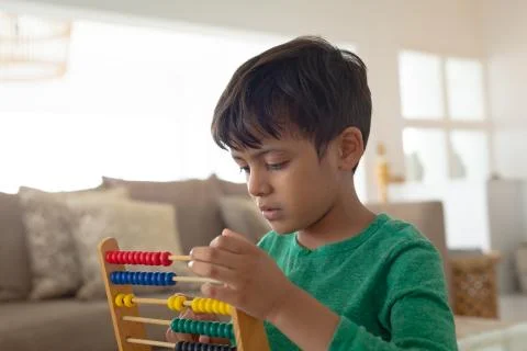 Boy learning mathematics with abacus in a comfortable home 写真素材