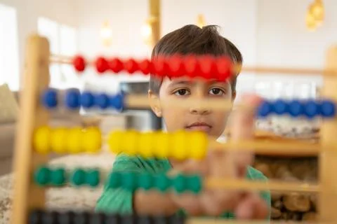 Boy learning mathematics with abacus in a comfortable home Stockfoto's