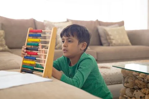Boy learning mathematics with abacus in a comfortable home Foto stock