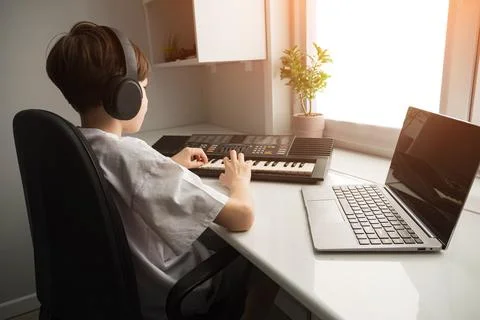Boy learning music at home studio with laptop Stock Photos