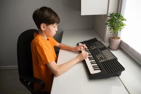 Boy learning playing keyboard instrument developing musical skills Stock Photos