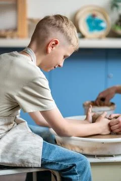 Boy learning pottery at a workshop, hands shaping clay on a pottery wheel Stock Photos