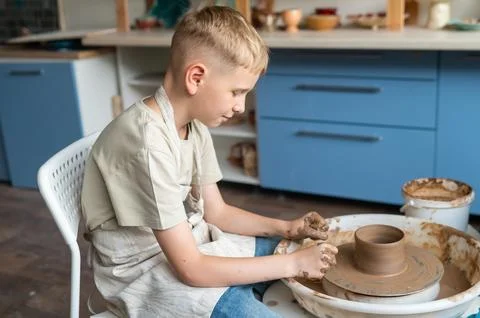 Boy learning pottery at a workshop, hands shaping clay on a pottery wheel Stock Photos