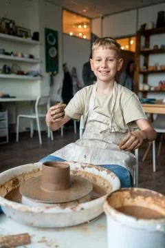 Boy learning pottery at a workshop, hands shaping clay on a pottery wheel Stock Photos