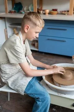 Boy learning pottery at a workshop, hands shaping clay on a pottery wheel Stock Photos