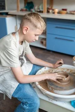 Boy learning pottery at a workshop, hands shaping clay on a pottery wheel Stock Photos