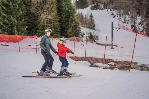 Boy learning to ski, training and listening to his ski instructor on the slope Stock Photos