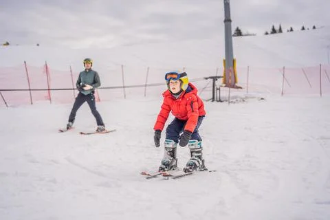 Boy learning to ski, training and listening to his ski instructor on the slope Foto stock