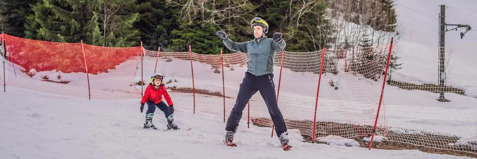 Boy learning to ski, training and listening to his ski instructor on the slope Stock Photos