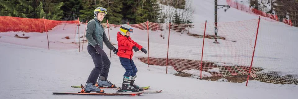Boy learning to ski, training and listening to his ski instructor on the slope Stock Photos