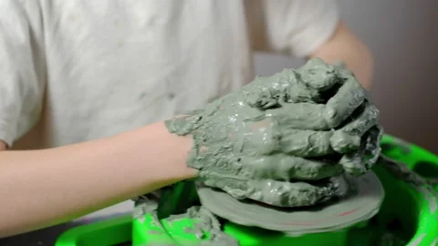 Boy learning to stick on a potter's wheel close-up Stock Footage 151642858