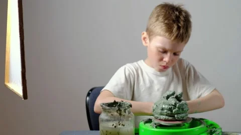 Boy learning to stick on a potter's wheel. Long or Wide Shot  Stock Footage 151643021