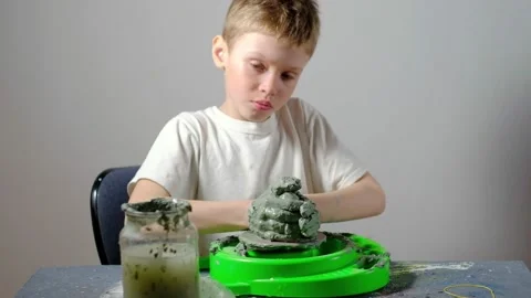 Boy learning to stick on a potter's wheel. Long or Wide Shot  Stock Footage 151643040