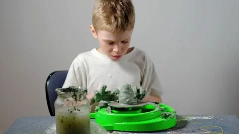Boy learning to stick on a potter's wheel. Long or Wide Shot  Stock Footage 151643066