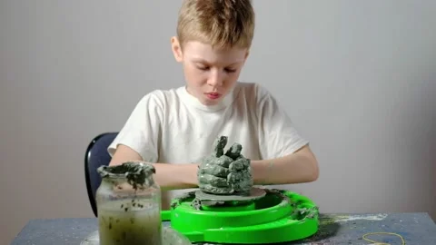 Boy learning to stick on a potter's wheel. Long or Wide Shot  Stock Footage 151643157