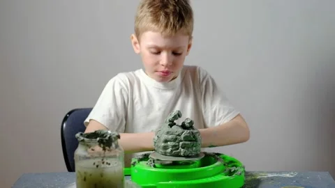 Boy learning to stick on a potter's wheel. Long or Wide Shot  Stock Footage 151643169