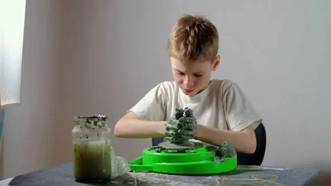 Boy learning to stick on a potter's wheel. Long or Wide Shot  Stock Footage 151643200
