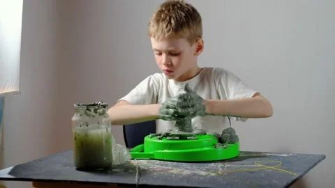 Boy learning to stick on a potter's wheel. Long or Wide Shot  Stock Footage 151643289