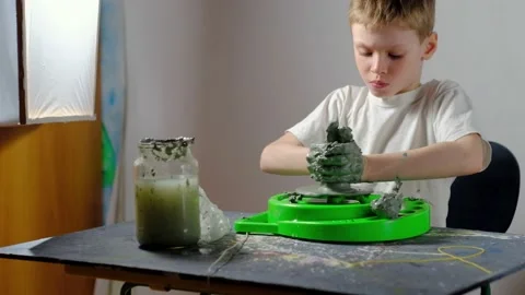 Boy learning to stick on a potter's wheel. Long or Wide Shot  Stock Footage 151643314