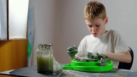 Boy learning to stick on a potter's wheel. Long or Wide Shot  Stock Footage 151643360