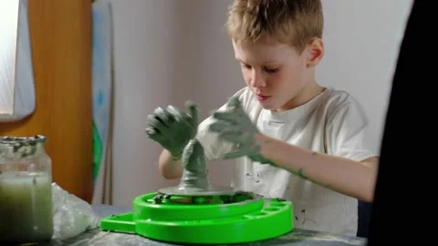 Boy learning to stick on a potter's wheel. Long or Wide Shot  Stock Footage 151643432