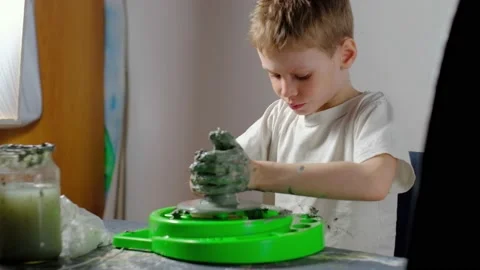 Boy learning to stick on a potter's wheel. Long or Wide Shot  Stock Footage 151643458