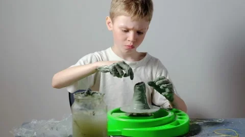 Boy learning to stick on a potter's wheel. Long or Wide Shot  Video stock 151644108