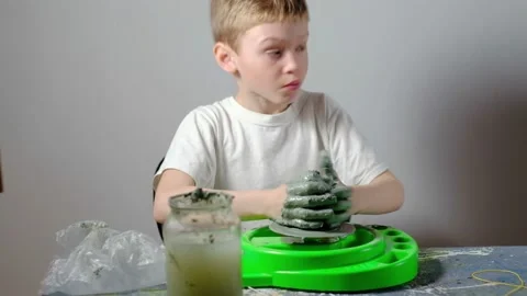 Boy learning to stick on a potter's wheel. Long or Wide Shot  Video stock 151644215
