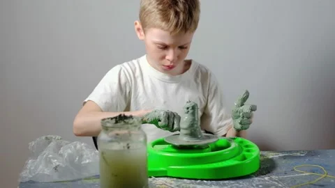 Boy learning to stick on a potter's wheel. Long or Wide Shot  Video stock 151644256