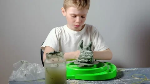 Boy learning to stick on a potter's wheel. Long or Wide Shot  Video stock 151644290