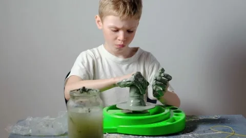 Boy learning to stick on a potter's wheel. Long or Wide Shot  Video stock 151644343