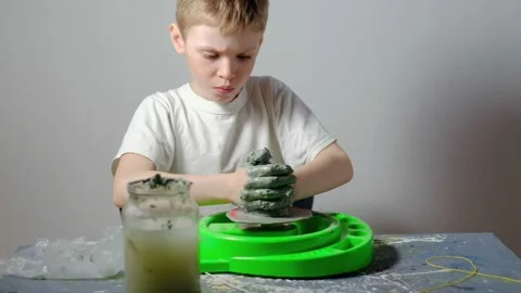 Boy learning to stick on a potter's wheel. Long or Wide Shot  Video stock 151644364