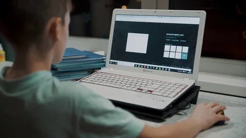 The boy learns the computer, presses on the keys and moves the mouse 動画素材 85117292