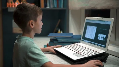 The boy learns the computer, presses on the keys and moves the mouse Stock Footage 85118293