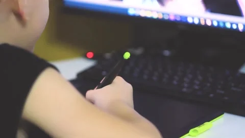 Boy learns to draw on graphics tablet. Drawing for pc. Stock Footage 220787138