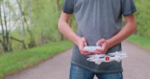 Boy learns to launch a drone. Man lifts the drone using the remote control. T Stock Footage 131041063