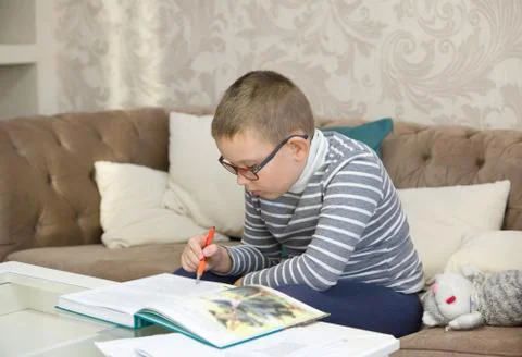 Boy learns to read a big book Stock Photos