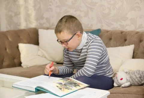 Boy learns to read a big book Stock Photos