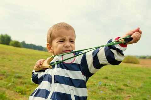 A boy learns to shoot a slingshot Stock Photos