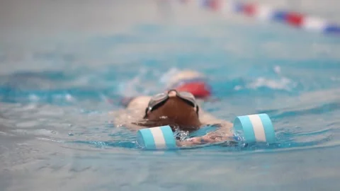 Boy learns to swim on his back Stock Footage 310060077