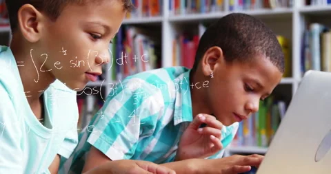 Boy on left gesturing at library laptop, boy typing as formulas appearing and Stock Footage 312360992