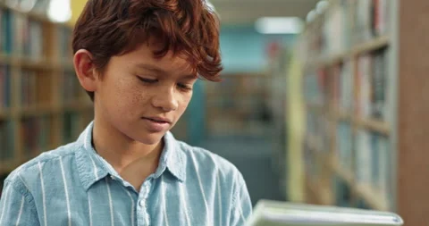 Boy, library and checking with book for story, literature or knowledge of Stock Footage 280453904