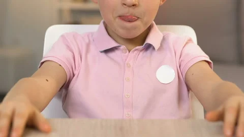 Boy licking lips, looking at tasty cake with love, unhealthy food for children Video stock 103804388