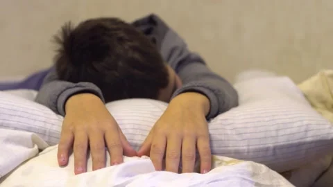 The boy lies on the bed 4K Video stock 219404533